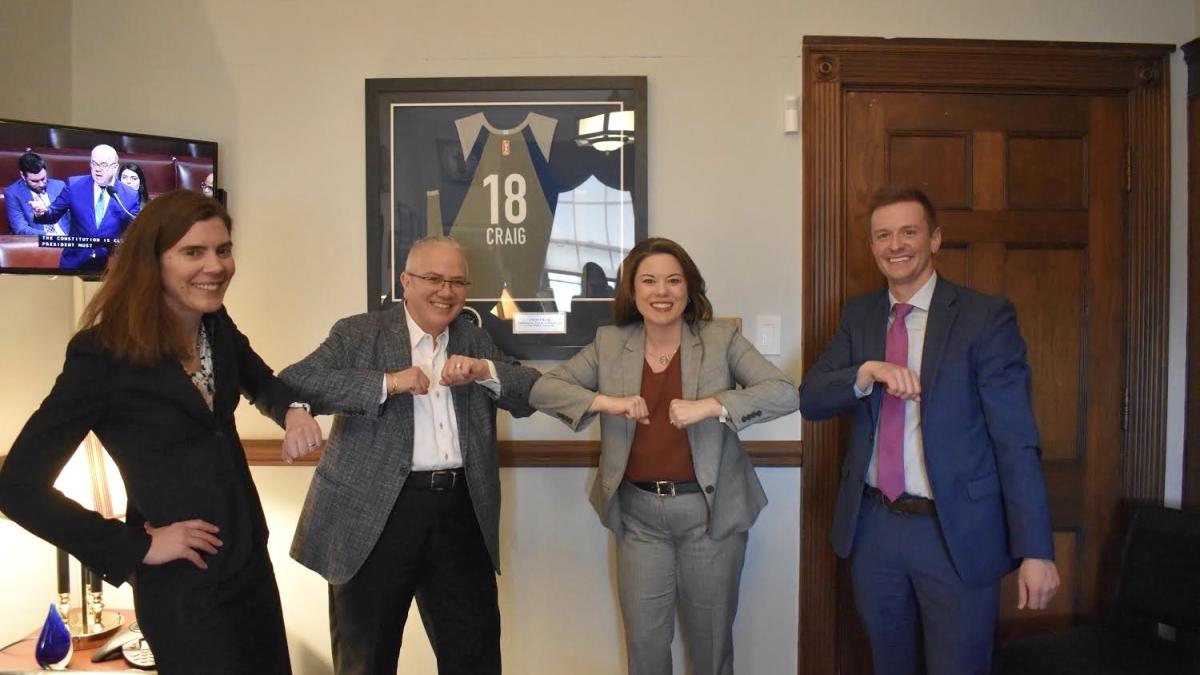 Rep. Angie Craig doing an “elbow bump” with Commissioner Jennifer Ho, Jessica Deegan and Ryan Baumtrog.